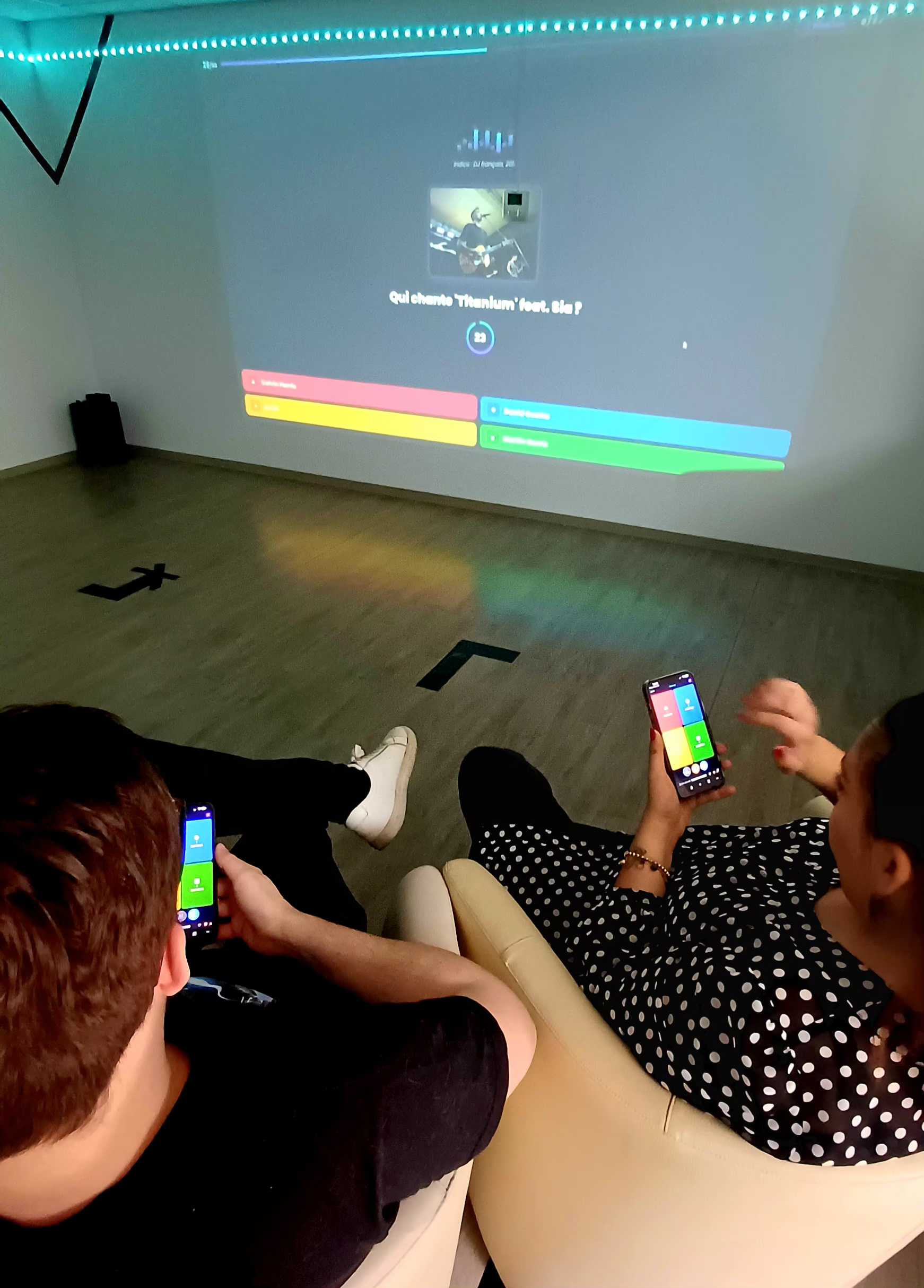 Joueurs utilisant leur téléphone comme buzzer pendant une partie de Quiz Infini